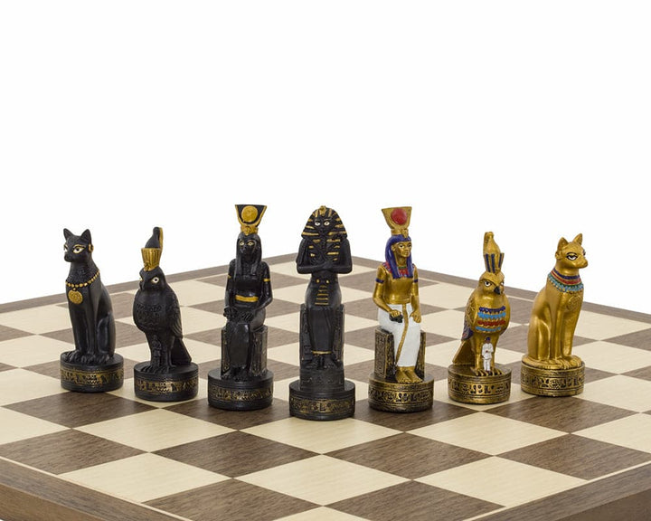 Ancient Egypt hand painted themed chess pieces by Italfama on a chessboard, featuring intricate gold and black designs.