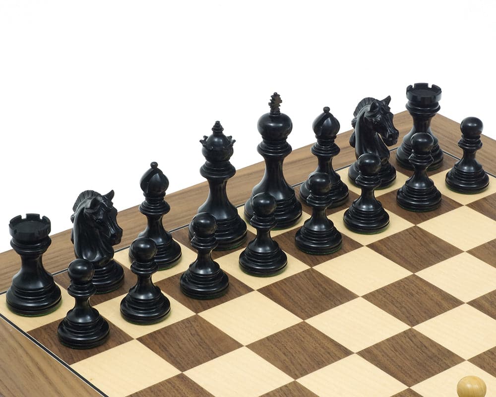 The Garvi Ebony Chessmen set up on a chessboard, featuring Staunton-style pieces with Mughal influence, crafted from ebony, with a 4-inch king.