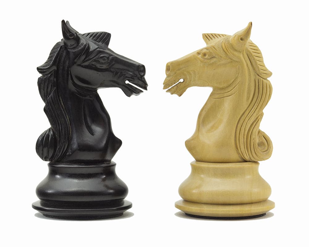 Two beautifully crafted knight chess pieces, one ebony and one ivory, from the Columbus Series Chessmen collection.