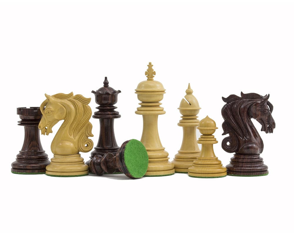 The Kingsgate Rosewood Chessmen 4.25 inch set with intricately carved knights, weighted bases, and green billiard cloth backing.