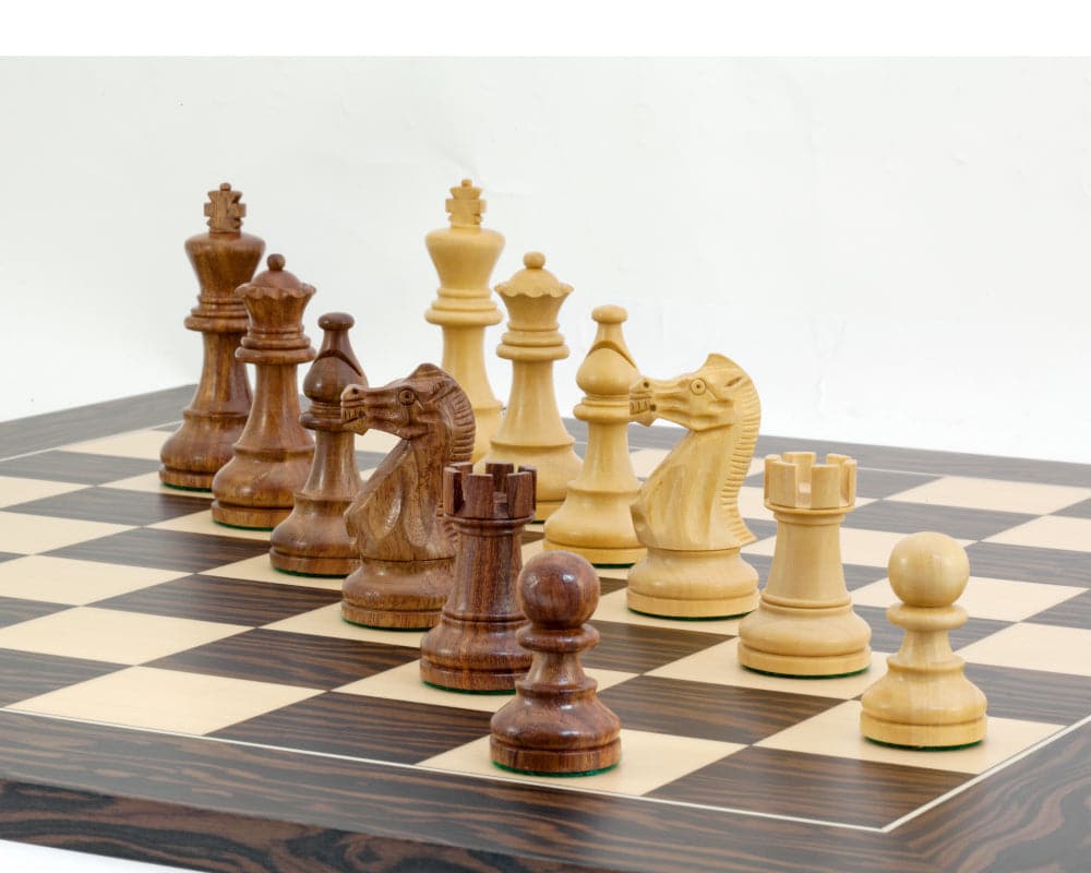 The Rochester Ebony Chessmen 4 inch with traditional Staunton design, weighted and covered bases on a chessboard for perfect balance and authenticity