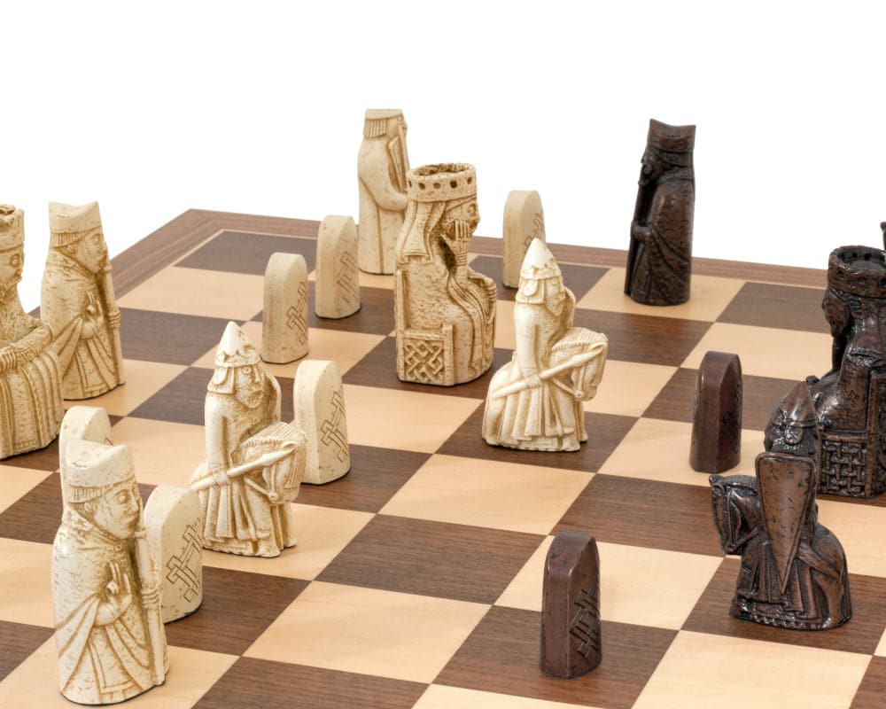 The Isle of Lewis walnut and maple chess set showing detailed reproductions of legendary chessmen on a wooden chessboard.