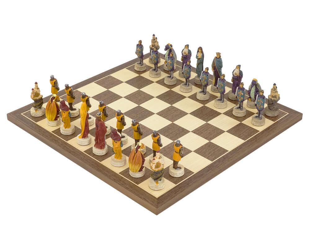 Medieval hand-painted chess set on Spanish board with vibrant red, orange, blue, and purple pieces inspired by King Arthur legends.