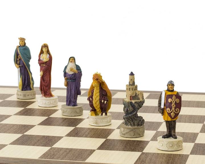 Hand-painted medieval chess pieces on Spanish board inspired by King Arthur, featuring vibrant red, orange, blue, and purple designs