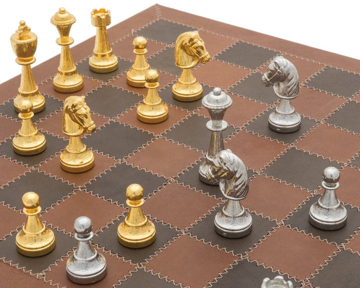 Gold and silver chess set on a brown Italian leather board from the Messina Luxury Collection.